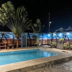 QuificaJUCENTE_ALOJAMENTO_LOCAL的棕榈树的夜间游泳池