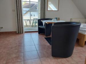 奥茨塞巴德·迪尔哈根Parkresidenz Dierhagen的一间用餐室,配有黑色椅子和桌子,并设有窗户