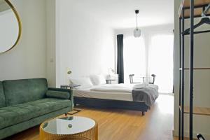 汉堡Apartmenthaus Hamburg Les Jardins的一间卧室配有一张床和一张绿色沙发