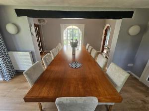 吉尔福德English Farmhouse Cottage的一间带木桌和椅子的用餐室