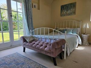 吉尔福德English Farmhouse Cottage的一间卧室配有一张床、一张沙发和一个窗口