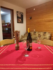 马考巴尔贾Apartment Doris Mrkopalj的一张桌子上放着一瓶葡萄酒,放上两杯