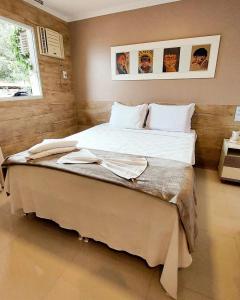 戈亚斯州上帕莱索塔皮搭雷酒店的一间卧室配有一张带白色床单的大床