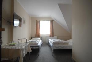 Boczów乌奥卡汽车旅馆的客房设有两张床、一张桌子和一扇窗户。