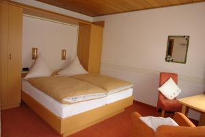 梅德巴赫豪斯赫斯贝格酒店的一间卧室配有一张带窗户和椅子的床