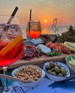 巴统Orbi City Sea View 24/7的一张桌子,上面放着两杯葡萄酒和一些食物