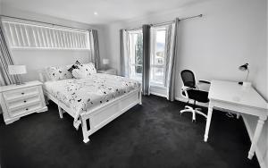 贝里代尔La Chablisienne - Unit的卧室配有白色的床、书桌和书桌。
