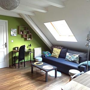鲁法克Joli gîte F2 indépendant avec jardin privé的客厅设有蓝色的沙发和天窗。