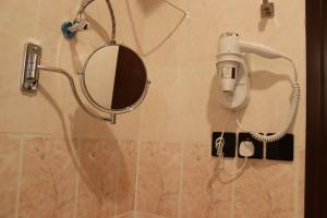 利雅德طيف المكان للشقق الفندقية的浴室墙上的镜子和吹风机