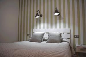 曼萨纳雷斯Casa Rístori Calicanto的一间卧室配有带2个枕头和2盏灯的床