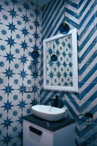 曼萨纳雷斯Casa Rístori Calicanto的浴室拥有蓝色和白色的瓷砖墙壁和水槽