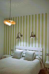 曼萨纳雷斯Casa Rístori Calicanto的一间卧室配有一张绿色和白色条纹的床