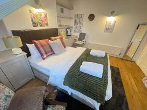 SurbitonLuxury Apartment in Surbiton, good access to London Waterloo的一间卧室配有一张带绿毯的大床