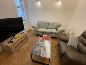 SurbitonLuxury Apartment in Surbiton, good access to London Waterloo的带沙发和电视的客厅