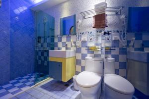 Dahan花莲七星潭七星彩虹海边民宿的蓝色瓷砖浴室设有卫生间和水槽