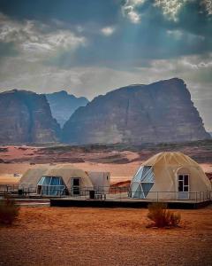 瓦迪拉姆Rum Mars luxury camp的沙漠中的两顶帐篷,背景是群山