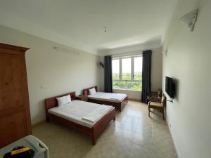 和平Thiên Bình Hotel的酒店客房设有两张床和窗户。
