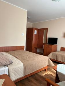 尤斯托尼莫斯基Chata Rybaka的一间卧室配有两张床和一台平面电视