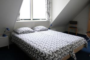 尤菲蒂赫伯格罗斯坎酒店的卧室配有一张带白色棉被的床和窗户。
