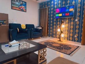 伊斯兰堡Morbex Guest House Islamabad的客厅配有蓝色的沙发和电视