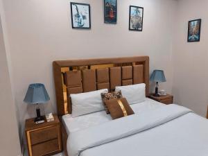 伊斯兰堡Morbex Guest House Islamabad的一间卧室配有一张床,在床头柜上配有两盏灯