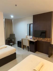 哥打巴鲁哥打巴鲁城特色公寓的酒店客房配有一张床、一张书桌和一台电视。