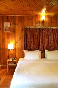 帕罗Sinchula Villa的木制客房内的一间白色床卧室