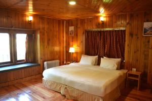 帕罗Sinchula Villa的木制客房内的一间卧室配有一张大床
