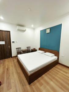 海防Đình Vũ 3 Motel的一间卧室设有一张蓝色墙壁的大床