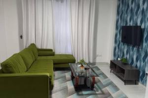 东勒贡Modern serviced apartment.的客厅配有绿色沙发和茶几