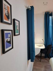 欧坦Art déco Paris Autun的配有床、桌子和蓝窗帘的房间