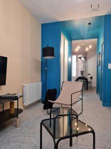 欧坦Art déco Paris Autun的客厅拥有蓝色的墙壁和桌椅