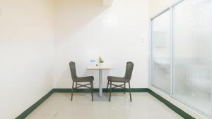 马尼拉RedDoorz @ Western Bicutan Transients Inn的一间带桌子和两把椅子的用餐室