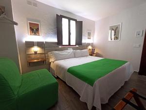 扎哈拉Casa Hotel LA JARANA的一间卧室配有一张大床和一张绿色椅子