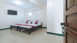 马尼拉RedDoorz @ Western Bicutan Transients Inn的一间卧室配有红色和白色枕头的床