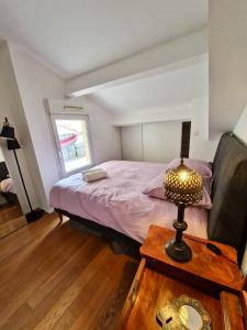马赛Colourful loft in Marseille的一间卧室配有一张床和一张带台灯的桌子