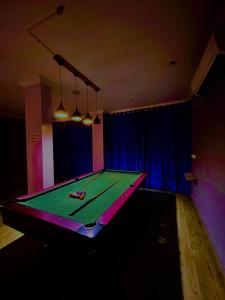 GoaHamilton Hotel & Resort Goa的暗室里的乒乓球桌,有广告
