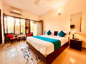 GoaHamilton Hotel & Resort Goa的一间带大床的卧室和一间带书桌的房间