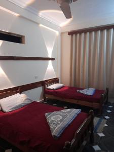 阿里什قريه جرين لاند العريش的客房设有两张床和一个带窗帘的窗户。