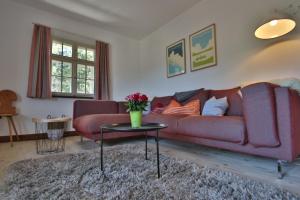 HinterfalkauFerienhaus Matz, Feldberg, Hochschwarzwald的客厅配有红色的沙发和桌子