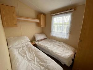 利文-法夫Caravan SK 110的小型客房 - 带2张床和窗户