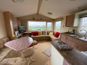 利文-法夫Caravan SK 110的厨房以及带沙发和桌子的客厅。