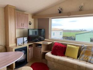 利文-法夫Caravan SK 110的带沙发、电视和窗户的客厅