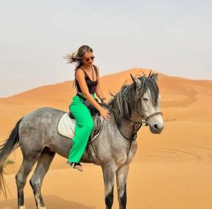 梅尔祖卡Desert Berber Camp的沙漠中骑马的女人