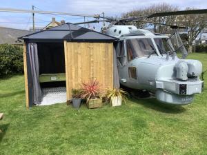 赫尔斯顿Haelarcher Helicopter Glamping的停泊在田野的直升机,有帐篷