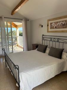 加莱里亚坎芭耶鲁酒店的一间卧室配有白色床单和阳台