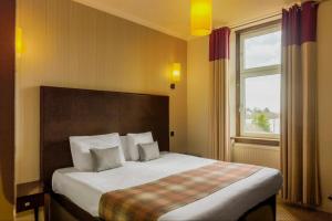 鲁阿BDL罗斯利大厅酒店的一间卧室设有一张大床和窗户