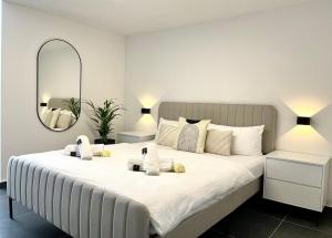 宾德拉赫Stilvolles Designappartment mit Terasse & Garten im idylischem Bindlach的卧室配有一张带镜子的白色大床