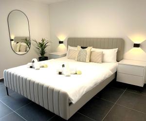 宾德拉赫Stilvolles Designappartment mit Terasse & Garten im idylischem Bindlach的一张大白色的床,位于带镜子的房间里