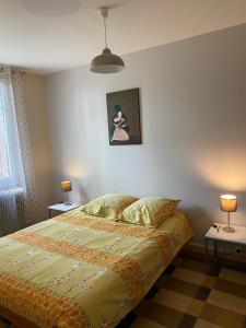 Monthou-sur-Cher奥克斯山度假屋的一间卧室配有一张带两张桌子和两盏灯的床。